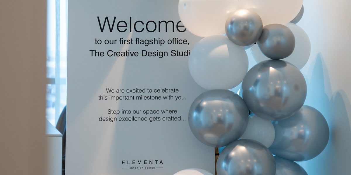 Welcome sign with silver and white balloons at Elementa's flagship office opening.