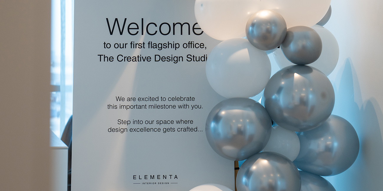 Welcome sign with silver and white balloons at Elementa's flagship office opening.