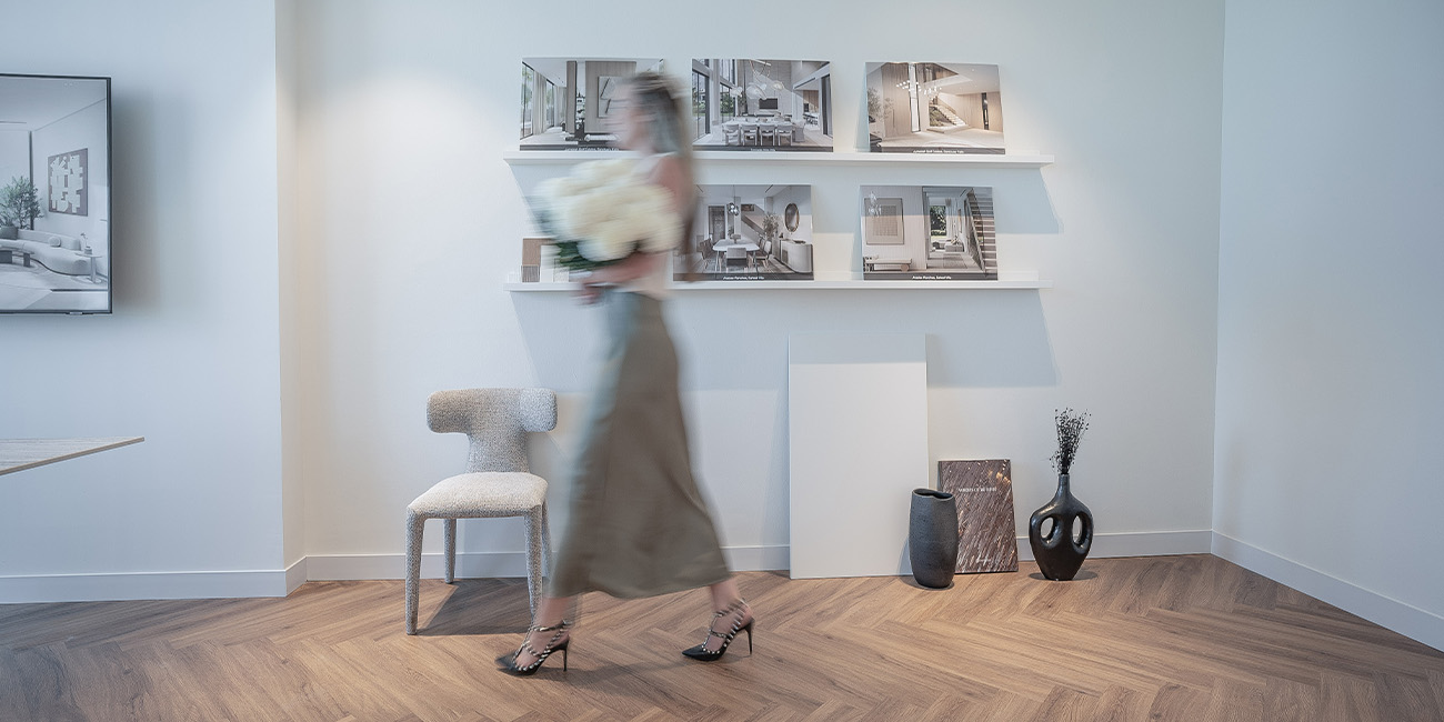 Woman walking with flowers in a modern room with wall art. Elementa Interior Design Dubai