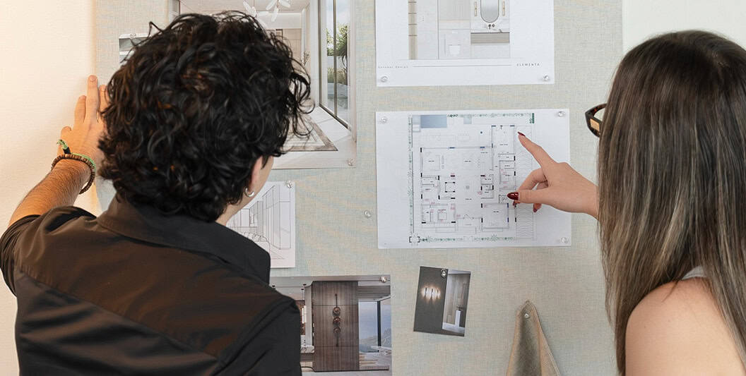 Modern interior design planning with two professionals reviewing architectural blueprints and design.