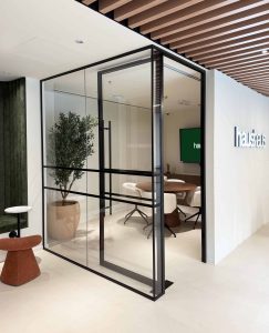 Modern glass-walled meeting room interior with stylish furniture and greenery at Elementa Interior D.