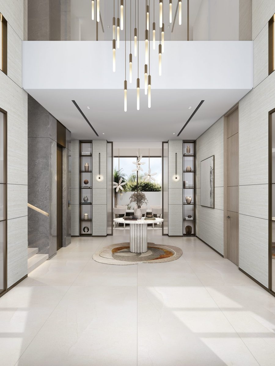 Double-height entrance hall of the Nad Al Sheba villa with a cascading glass chandelier and a marble floor inlay